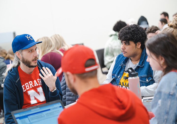 Andrew Hanna, assistant professor of practice in management and entrepreneurship, checks in with Mohamed Al Hussaini and his teammates as they decide their next steps in the competition.