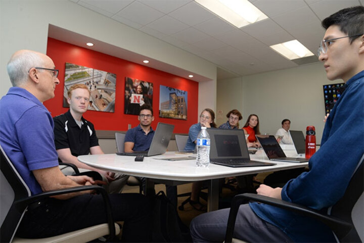 Aaron Wang (far right) listens to Dr. David Rosenbaum, professor of economics and associate professor of the Bureau of Business Research, explain research objectives to fellow Bureau of Business Research Scholars.