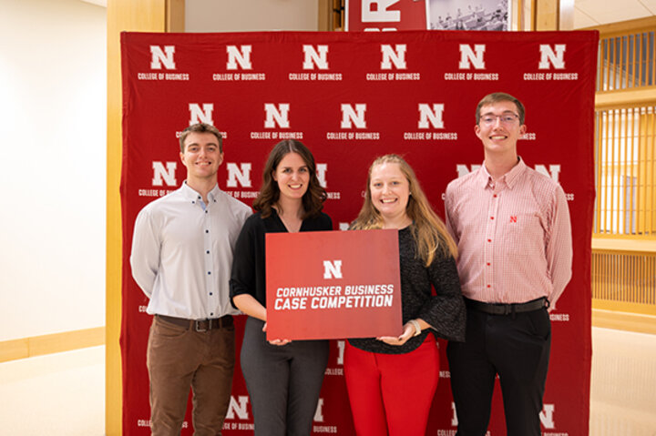 Student coordinators of the competition standing with a Cornhusker Business Case Competition plaquette.