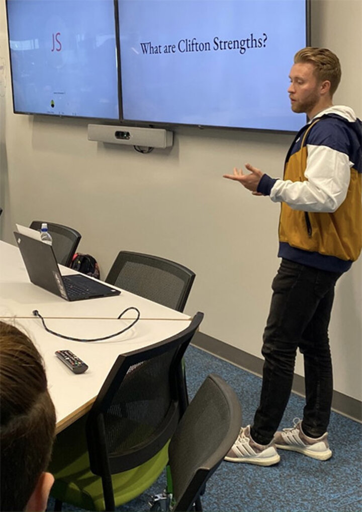 Tyler Clark gives a presentation on strengths to his colleagues.