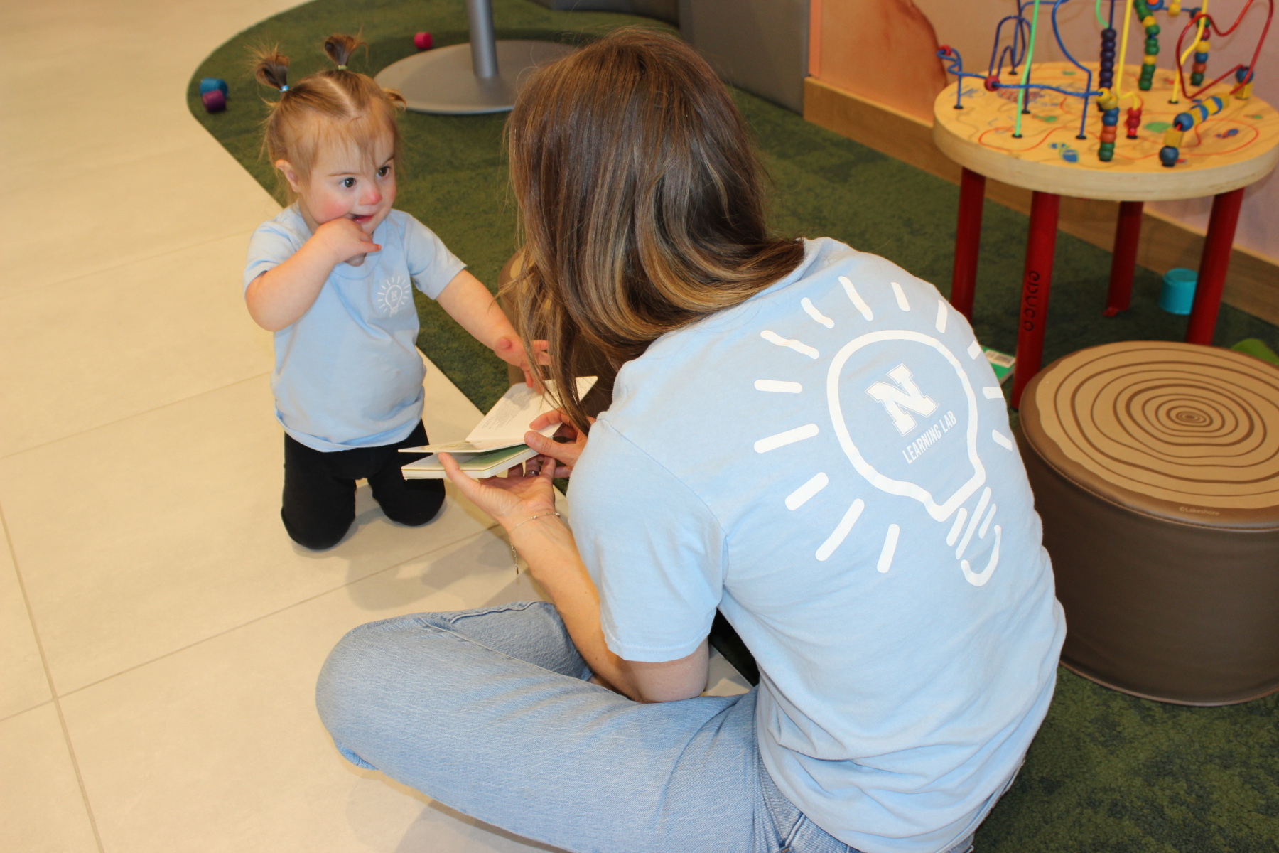 Womnan showing book to little child