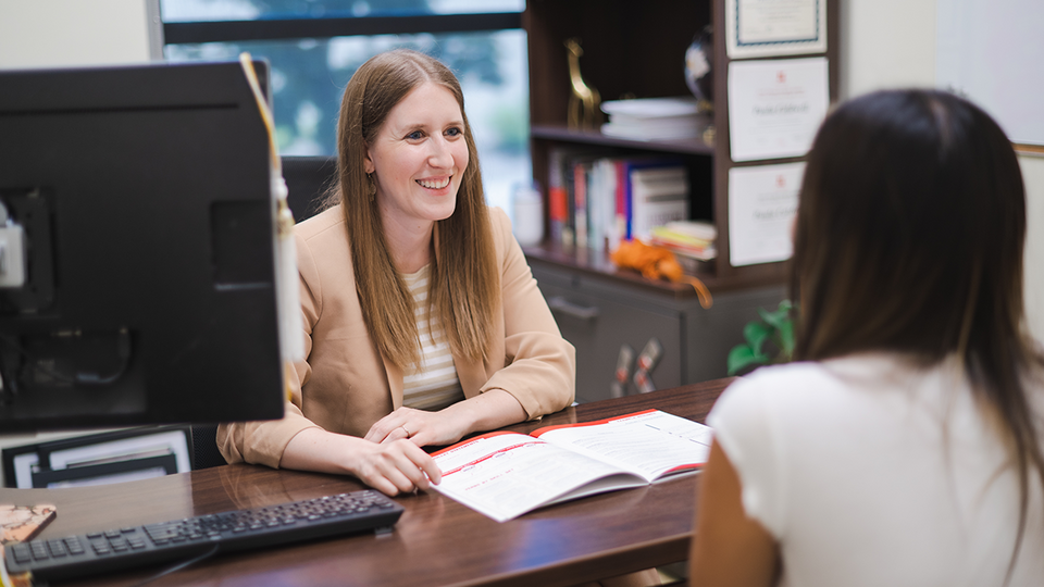 Student and career coach engaging in conversation in an office