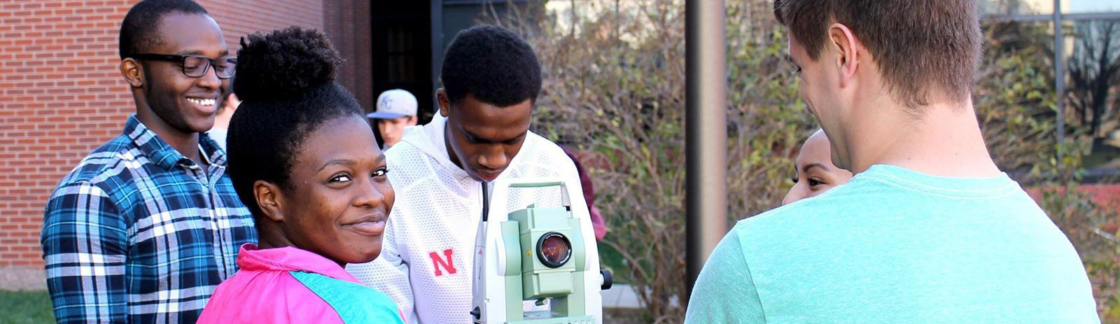 Four students using engineering surveying equipment