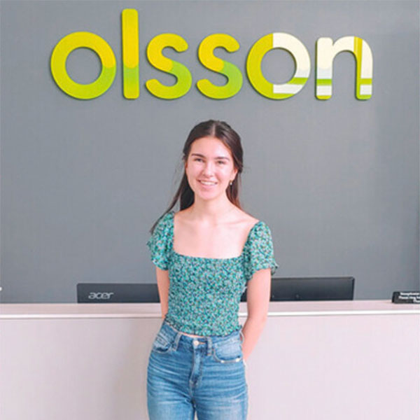 Mia Toigo standing under the olsson sign