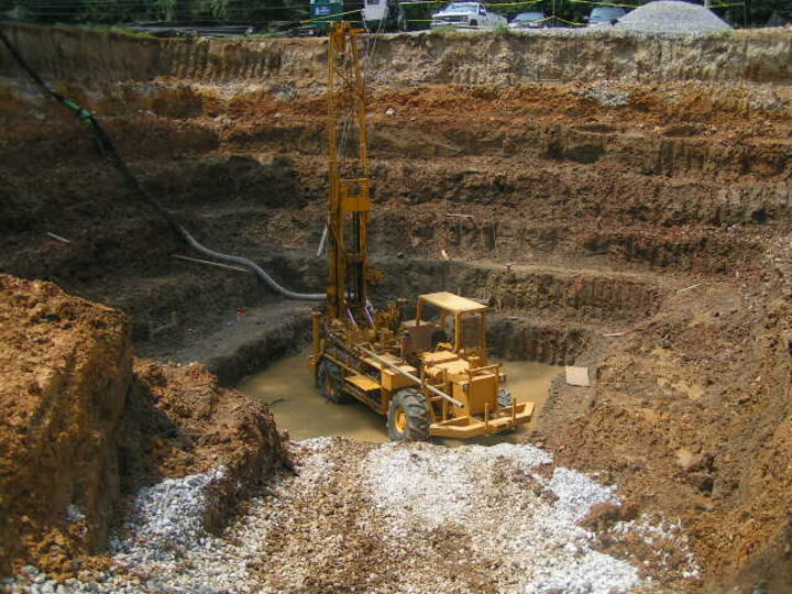 A backhoe in the bottom of a pit of dirt