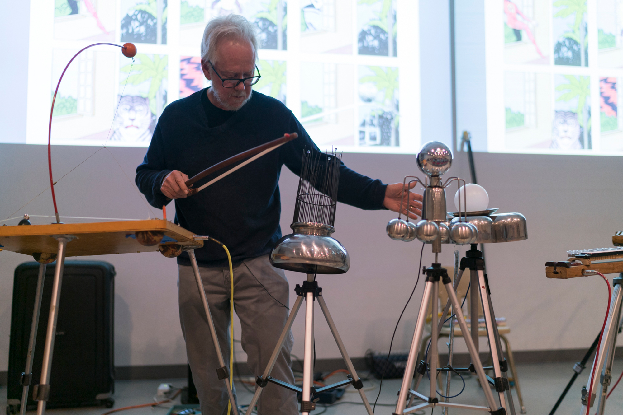 Jay Kreimer stands in front of projected images and amongst their special instruments.