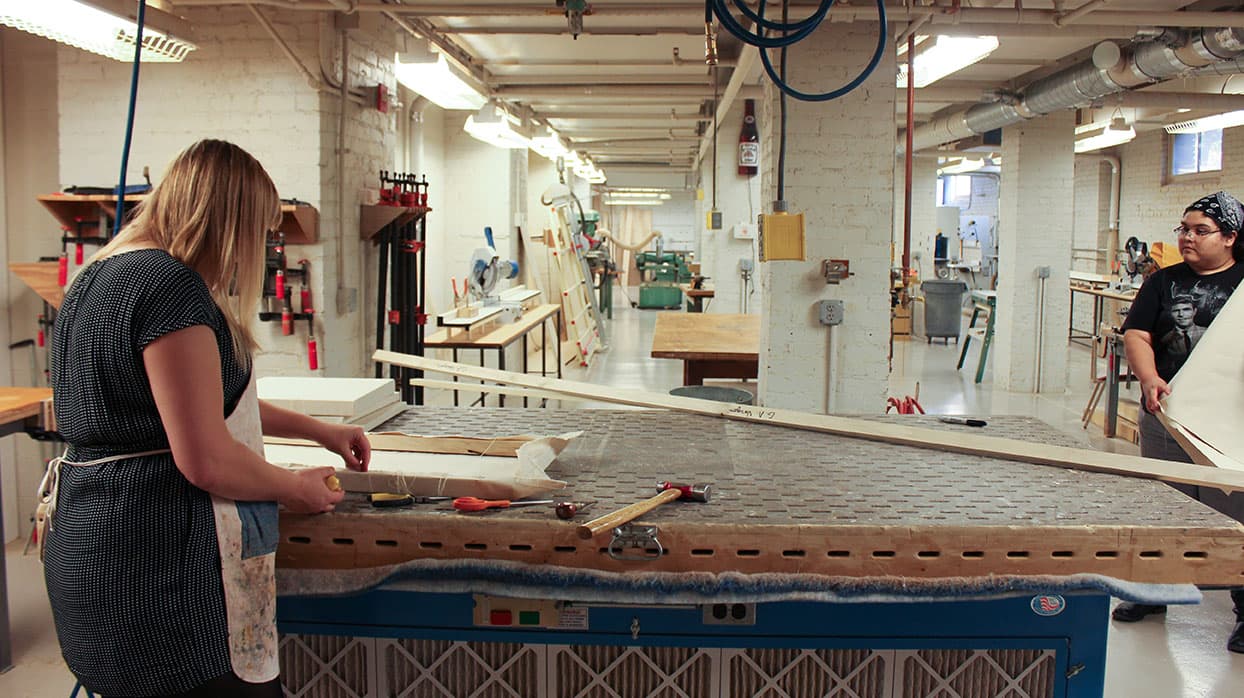 A student works at a workbench.