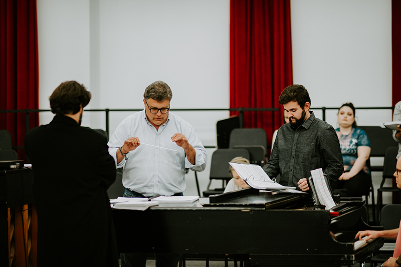 People stand around focused on conducting.