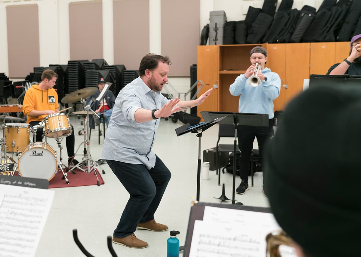 A conductor guides musicians.