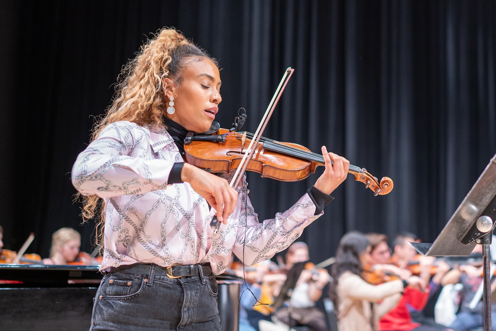 A women plays violin on stage.