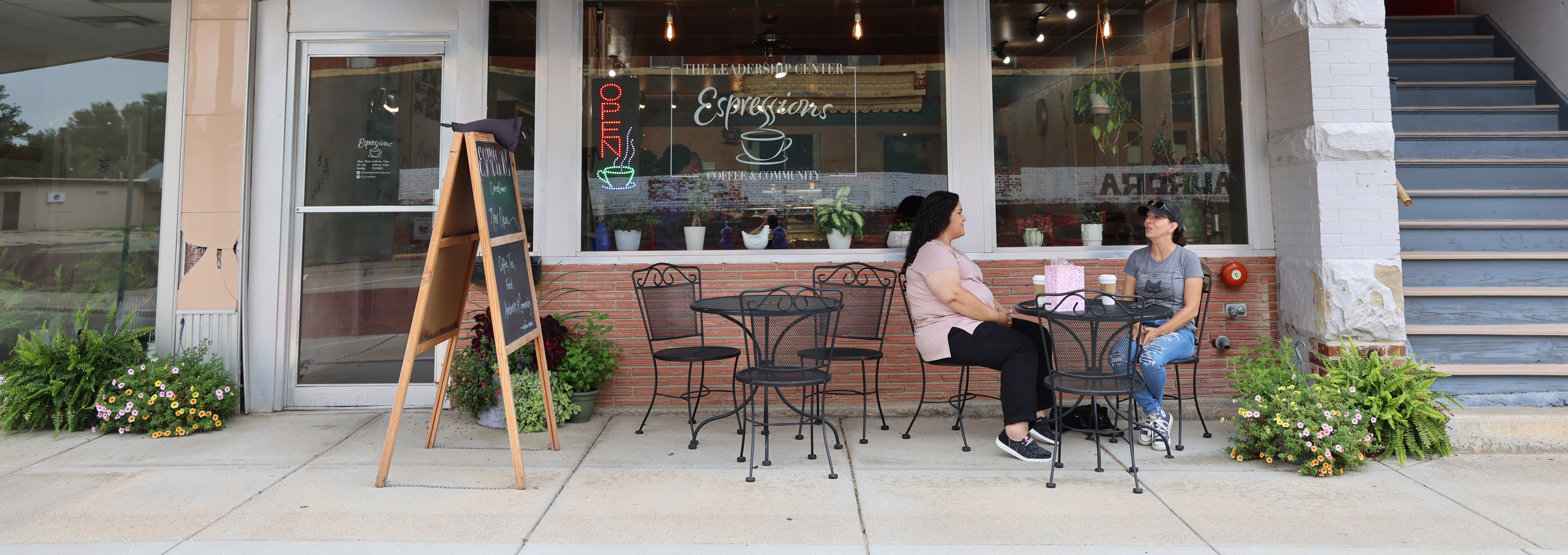 Two women sit outside a coffee shop in Aurora, Neb.