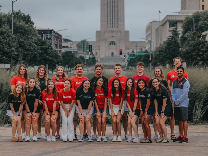 Group of students stands in front of the Nebraska State Capital. 