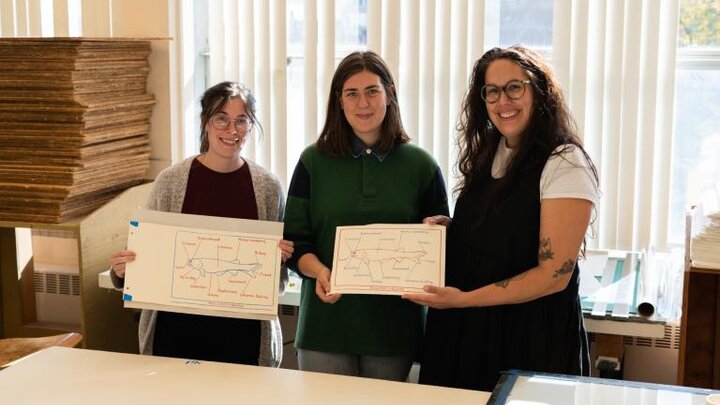 Left to right: Graduate students Sarah Jentsch, Kim Tomlinson and Hannah Demma with the edition of prints they created with Mark Dion. The image is of a lobe-finned fish surrounded by a list of terms that refer to corruption. Photo by Eddy Aldana.