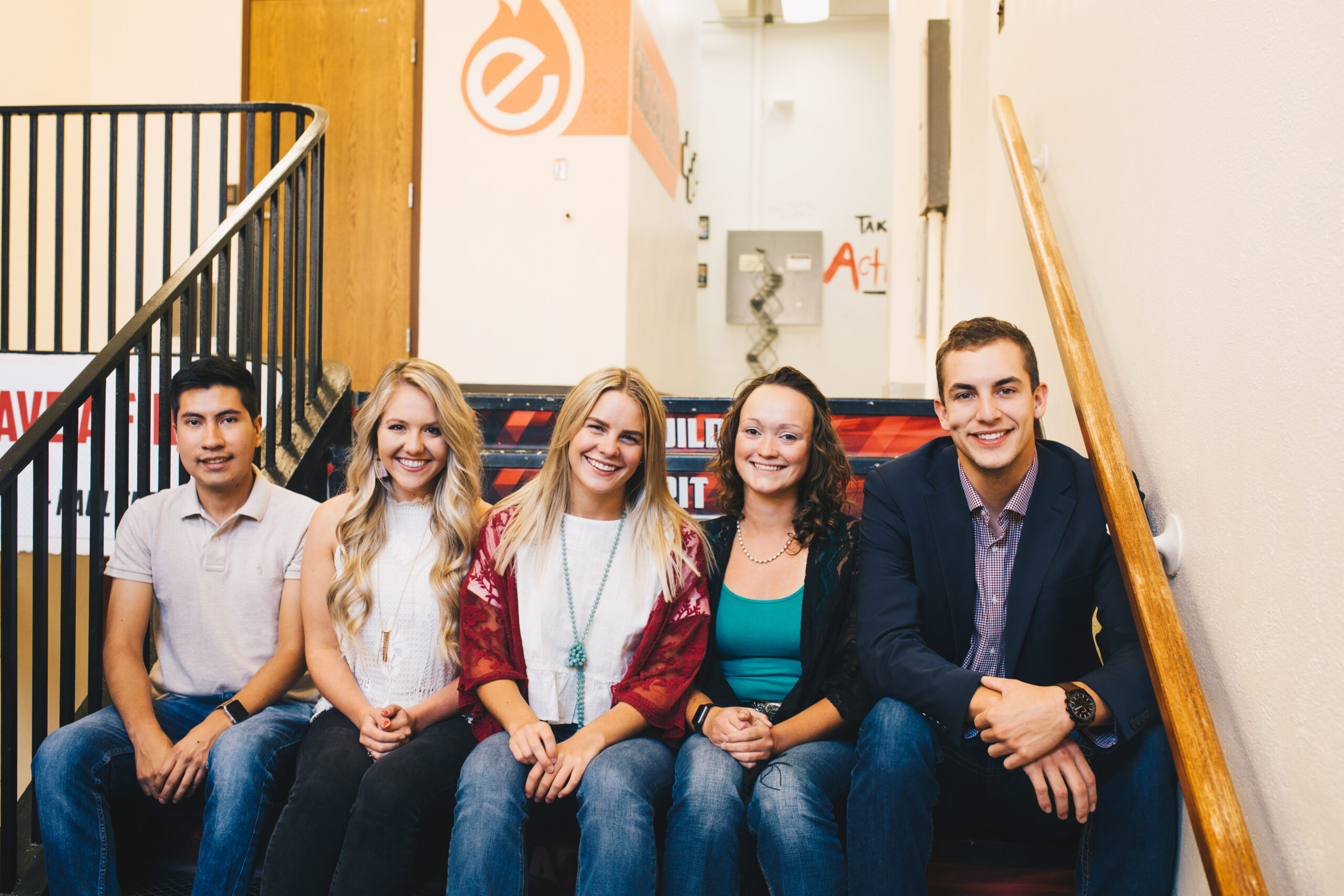 Five smiling Engler students sitting on stairs.