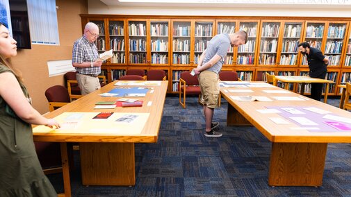 Tables with archive materials and people viewing them.