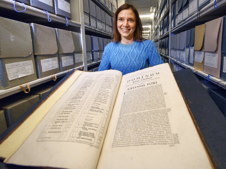 Archives librarian holding an open book