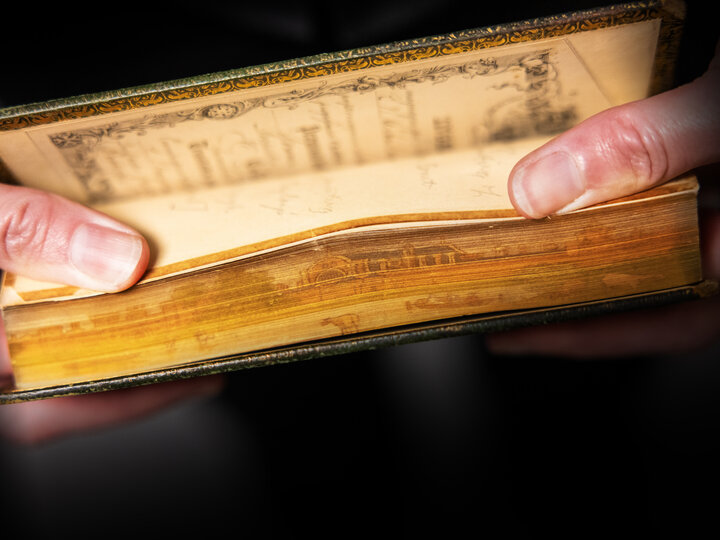 Photo of an archive book with an image embedding into the edge of the pages