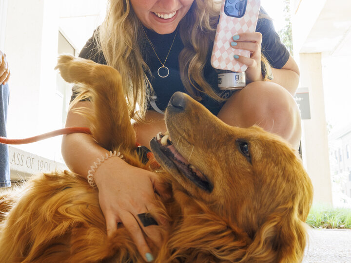 Photo of student petting a dog during a Big Red Pawp Up event