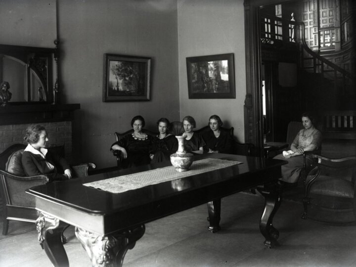 Photo of students in a cottage sitting around a table.