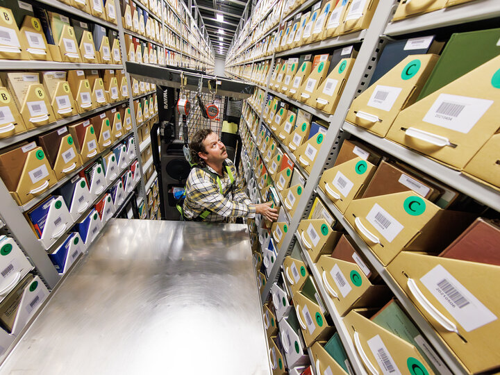 Photo of staff member on lift retrieving books from the LDRF